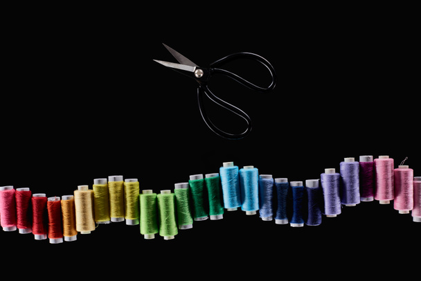 vista superior de fios brilhantes e coloridos e tesouras isoladas em preto
 - Foto, Imagem