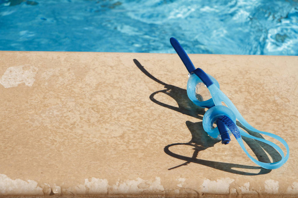Gafas de color azul claro para nadar se encuentran en el lado de la natación
  - Foto, Imagen