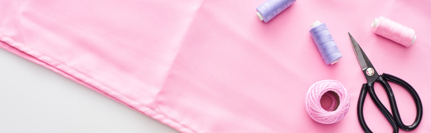 plan panoramique de tissu, boule de fil à tricoter, ciseaux et fils sur fond blanc
  - Photo, image