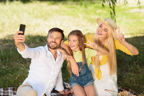 Famille joyeuse faisant selfie à l'extérieur dans le parc
 - Photo, image