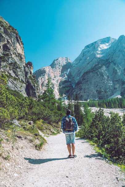 giovane con zaino a piedi in montagna sentiero nella giornata di sole
 - Foto, immagini