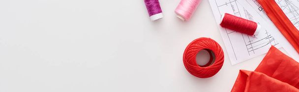 plan panoramique de fils colorés, boule de fil à tricoter, tissu, motifs de couture et fermeture éclair sur fond blanc
  - Photo, image