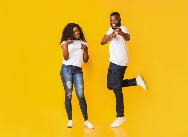 Gioioso giovane afro coppia puntando il dito contro la fotocamera
 - Foto, immagini