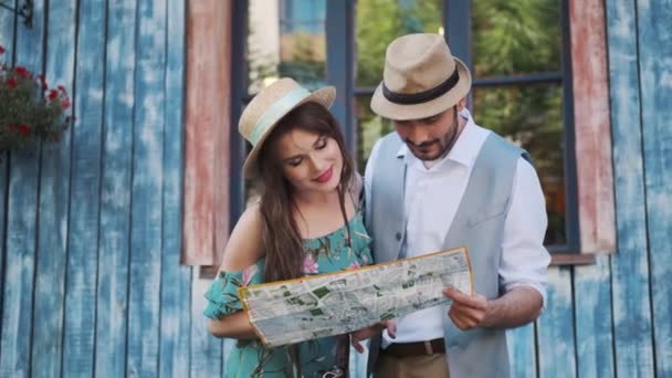 gelukkige toeristen reizen. een man en een vrouw houden een kaart van de stad - Video