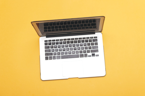 modern laptop isolated on yellow background - Foto, afbeelding