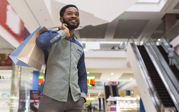 Handsome african man with purchases waiting for girlfriend - Photo, Image