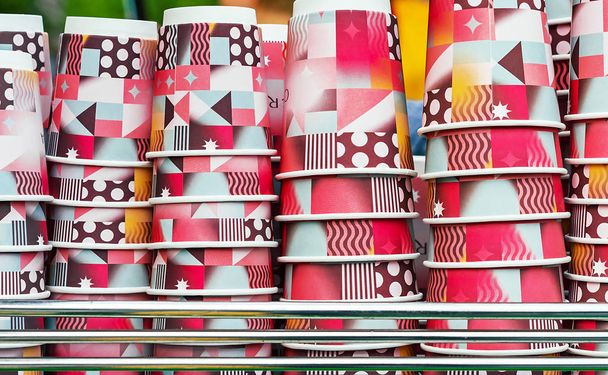 Bright disposable cups on the counter of an outdoor cafe. Paper cups for various drinks. - Photo, Image