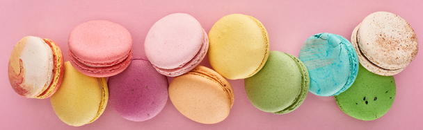 top view of fresh delicious French macaroons on pink background, panoramic shot - Фото, зображення