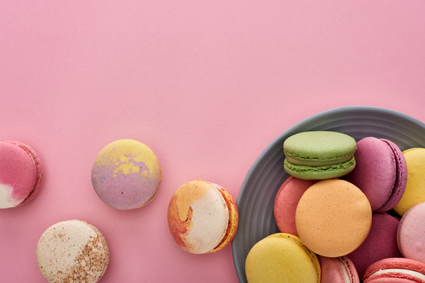 plate with multicolored fresh delicious French macaroons on pink background - Zdjęcie, obraz
