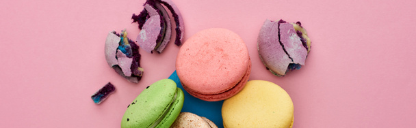 top view of multicolored delicious French macaroons in blue postal envelope on pink background, panoramic shot - Foto, immagini