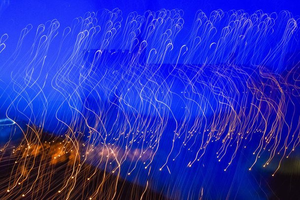Абстрактный синий и желтый фон несфокусированных и движущихся огней
. - Фото, изображение