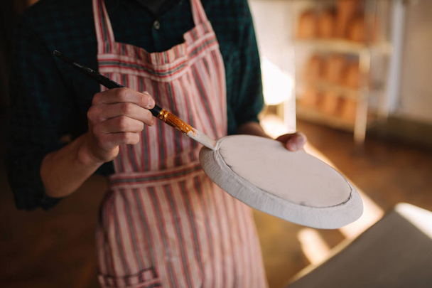 Lähikuva savenvalajat kädet tehdä koriste keraaminen tuote. Lautanen miesten käsissä. Nuori taiteilija
 - Valokuva, kuva