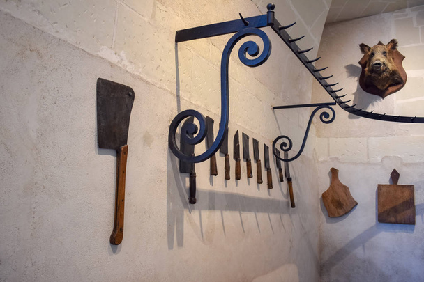Recreación del antiguo castillo del carnicero. Cuchillos y trofeo de caza con cabeza de jabalí, colgados en las paredes
. - Foto, imagen