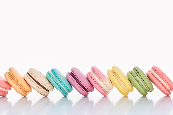 row of delicious colorful French macaroons of different flavors on white background with copy space - Photo, image