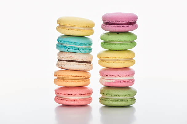 two rows of sweet multicolored French macaroons of different flavors on white background - Photo, Image