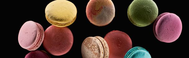heap of delicious colorful French macaroons of different flavors isolated on black, panoramic shot - Фото, зображення