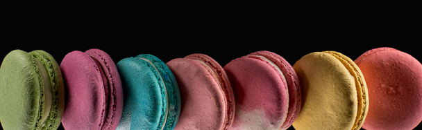 row of tasty colorful French macaroons of different flavors isolated on black, panoramic shot - Photo, Image