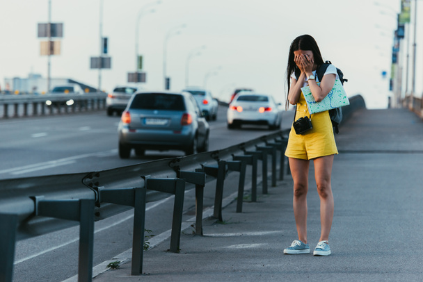 грустная женщина в желтом комбинезоне плачет и держит карту
  - Фото, изображение