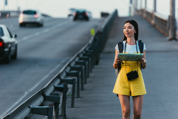 asian and beautiful woman in overalls holding map and looking away  - Photo, Image