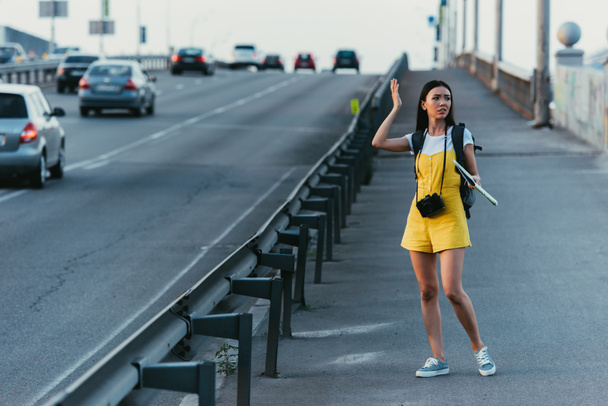 Aziatische en mooie vrouw in overalls houden kaart en op zoek weg  - Foto, afbeelding