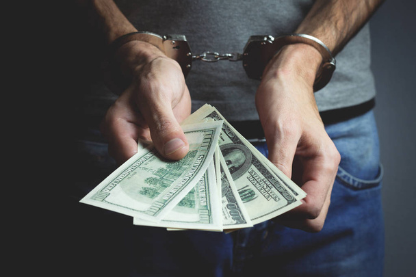 hand money and handcuffs - Foto, afbeelding