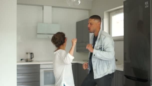 Cool young Caucasian pair having fun in their new apartment and rejoicing in slowmotion. Concpet of happines and joy - Filmati, video
