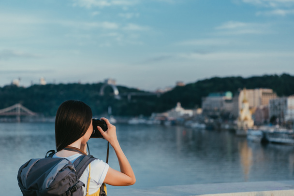 back view of brunette woman with backpack taking photo  - Photo, Image