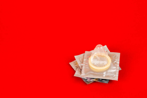 Kondom auf rotem Hintergrund. Safe-Sex-Konzept - Foto, Bild