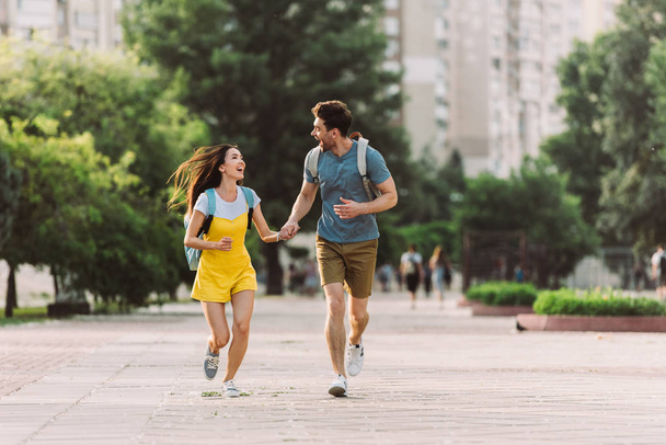 handsome man and asian woman running and looking at each other  - Photo, image