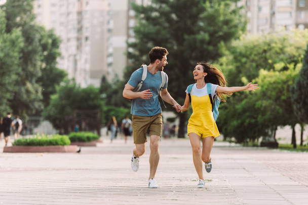 guapo hombre y asiático mujer corriendo y mirando el uno al otro
  - Foto, Imagen