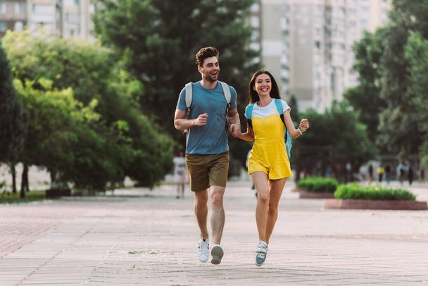 handsome man and asian woman running and looking away  - Foto, imagen