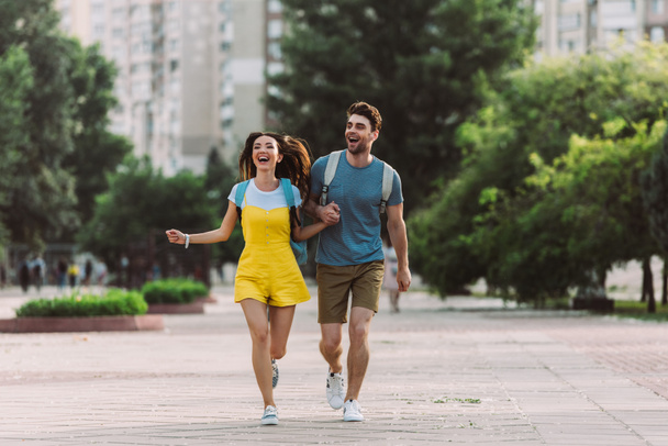 handsome man and asian woman running and looking away  - Photo, Image