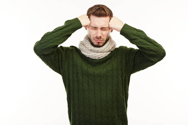 Man in a green sweater has a disturbing headache. - Photo, Image