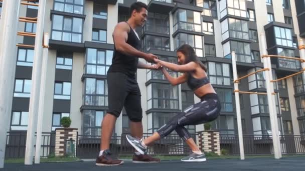 Youn boldog sportos házaspár csinál zömök együtt, az ember és a nő kezében együtt állva, - Felvétel, videó