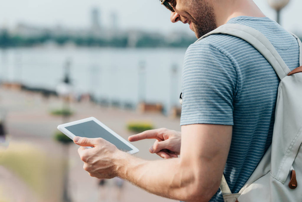 cropped view of man in glasses with backpack using digital tablet  - Photo, Image