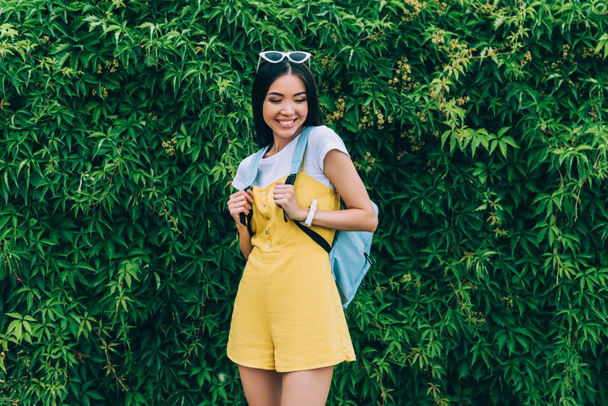 asian and attractive woman in overalls smiling and looking down  - Fotoğraf, Görsel