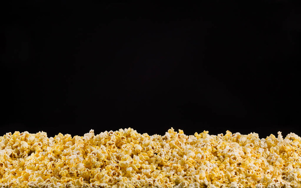 Scattered popcorn isolated on black background - Foto, Bild