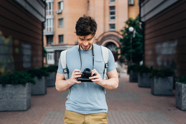 handsome man in t-shirt smiling and looking at digital camera - Foto, Imagen