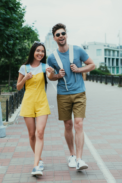 jóképű férfi és ázsiai nő gyalogos és látszó el  - Fotó, kép