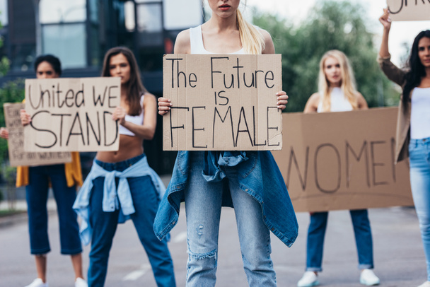 cropped view of woman holding placard with inscription the future is female near feminists on street - Fotó, kép