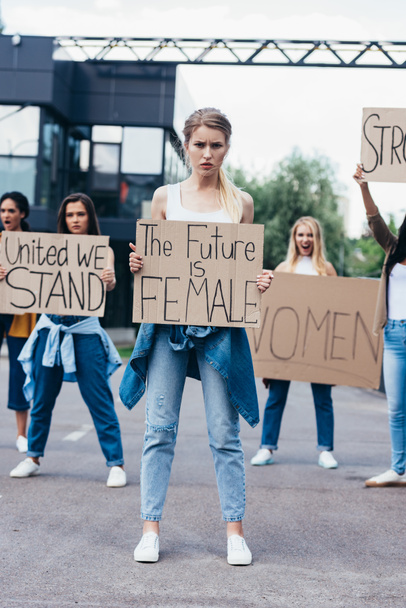 full length view of multiethnic feminists holding placards with slogans on street - Photo, Image