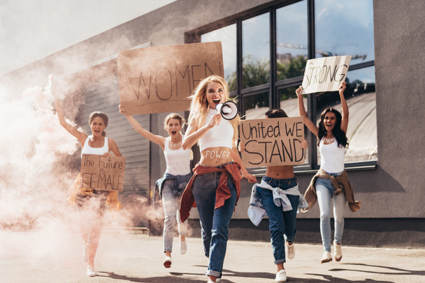 full length view of screaming feminists with loudspeaker holding placards with slogans and running on street - Fotografie, Obrázek