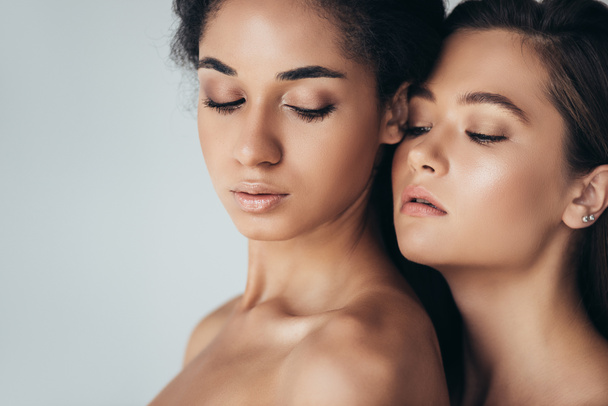 two attractive multiethnic young women with closed eyes isolated on grey - Fotoğraf, Görsel