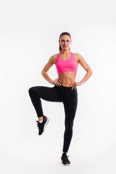 Full length portrait of a healthy young fitness woman doing exercises over white background - Photo, Image