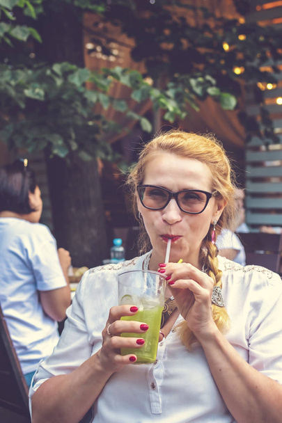 Mulher bonita de meia idade com coquetel no restaurante ao ar livre
. - Foto, Imagem