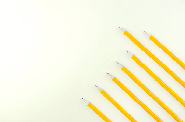 Yellow background with simple pencils scattered chaotically. - Foto, afbeelding