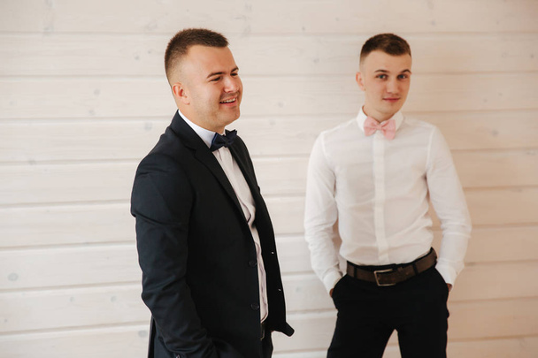 Handsome groom with his groomsman at home. Five man. Groom dressed in suit, gromsmen in white shirt. Funny guys on the wedding - Zdjęcie, obraz