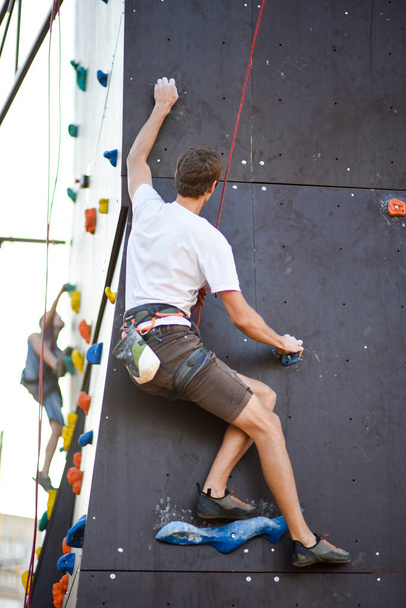 Uomo con braccia larghe concentrato e prepararsi a parete arrampicata
 - Foto, immagini