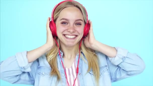 Dancing girl listens to music in earphones - Materiał filmowy, wideo