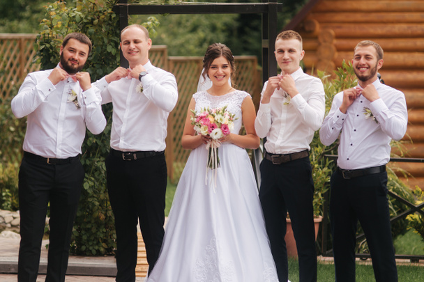 Charming bride stand by the groomsman on the backyard - Photo, Image